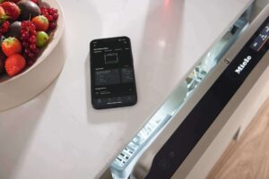Smarte Küchengeräte: Miele Geschirrspüler mit Miele App auf dem Smartphone